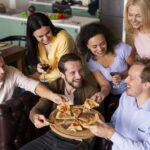 plano-medio-gente-feliz-comiendo-pizza